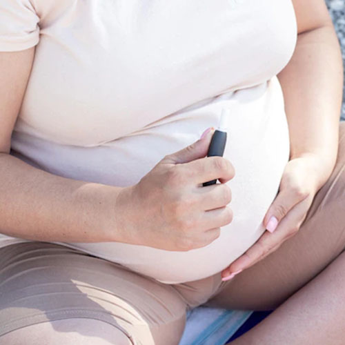 Femme enceinte avec e-cigarette à la main