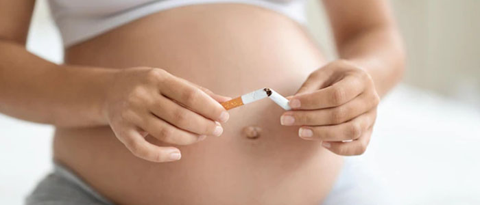 Femme enceinte cassant une cigarette