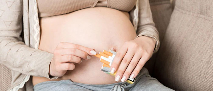 Femme enceinte avec un paquet de cigarettes