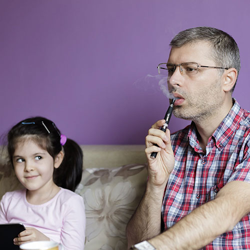 Père vapotant près de sa fille