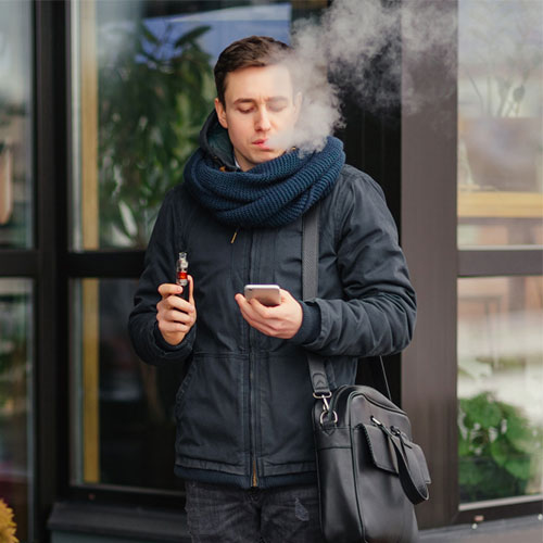 Jeune homme en train de vapoter